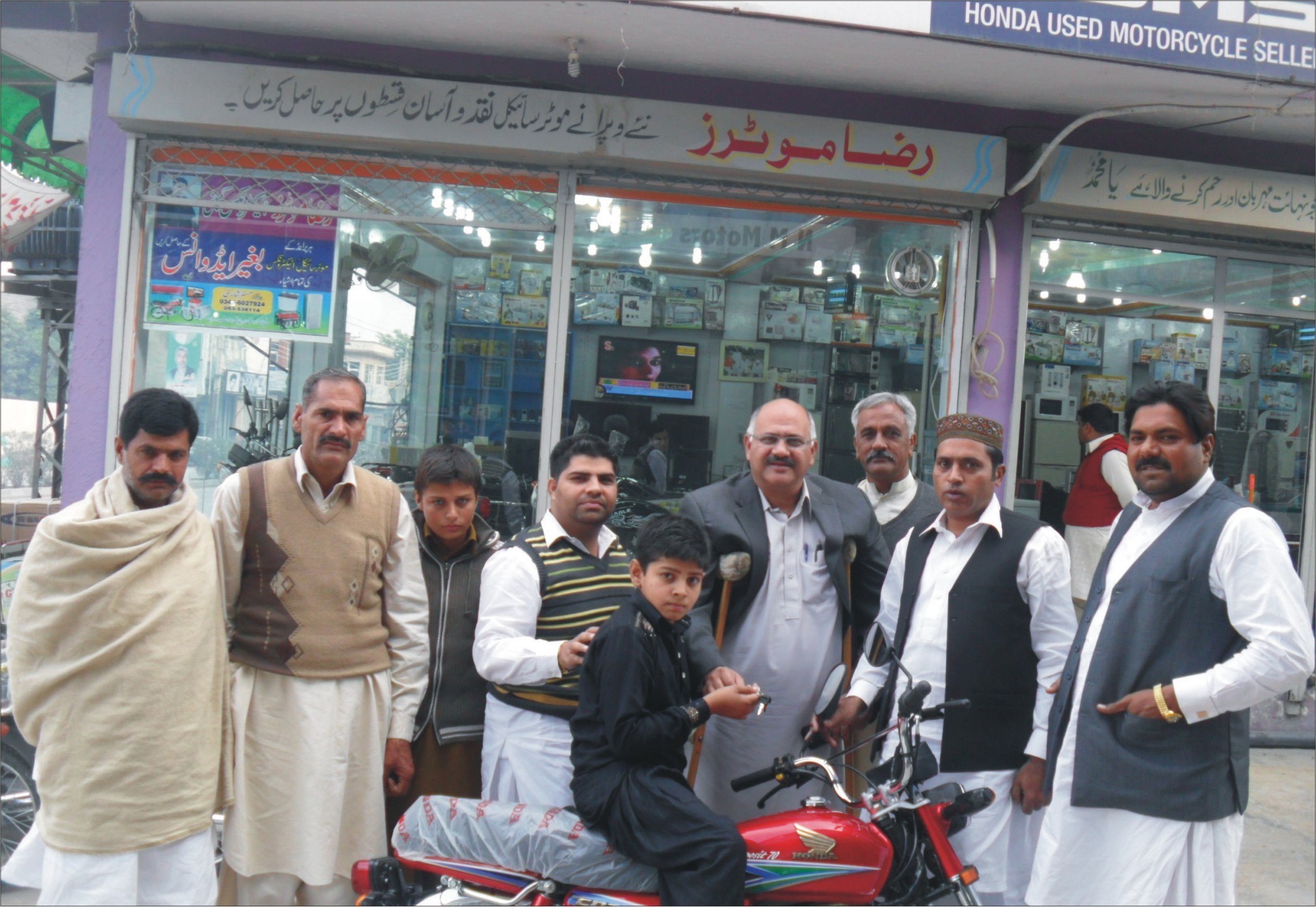محمد حبیب بسوی اور دیگر لکی کمیٹی کے ونر محمد عثمان ولدار ارشد کو موٹر سائیکل کی چابی دیتے ہوئے