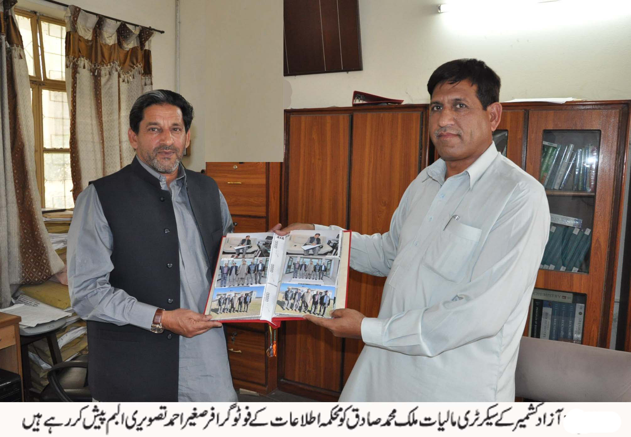 ملک محمد صادق کو محکمہ اطلاعات کے فوٹوگرافر صغیر احمد تصویری البم پیش کر رہے ہیں