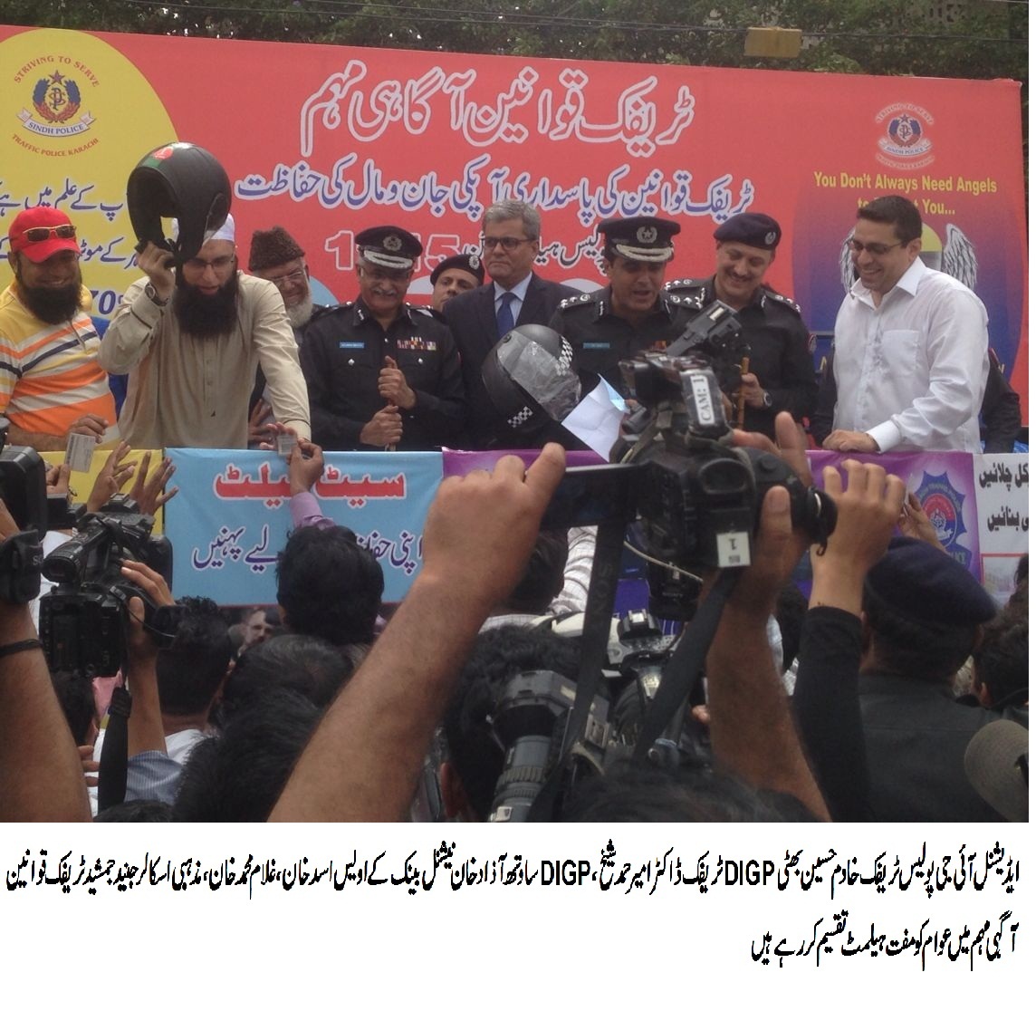 خادم حسین بھٹی اور دیگر  ٹریفک قوانین آگہی مہم میں عوام کو مفت ہیلمنٹ تقسیم کر رہے ہیں