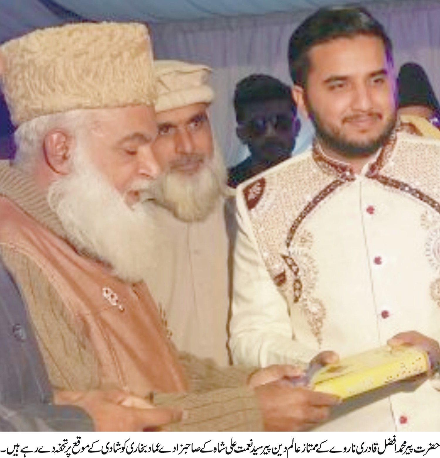 پیر افضل قادری  ممتاز عالم دین پیر سید نعمت علی شاہ  کے صاحبزادے  عماد بخاری کو شادی کے موقع پر تحفہ دے رہے ہیں