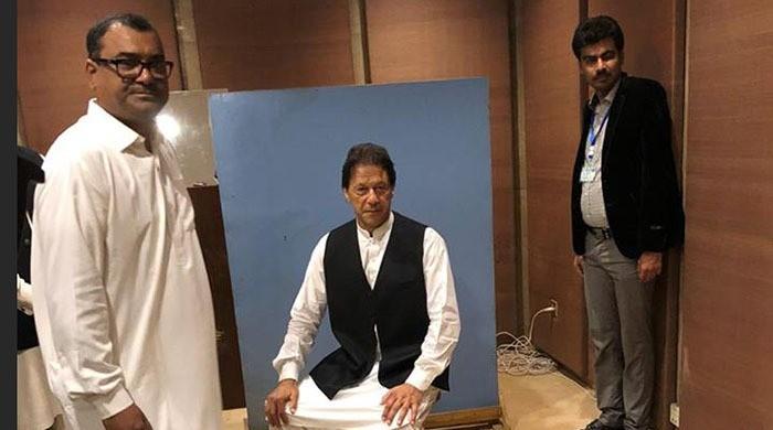 عمران خان نے پارلیمنٹ کے ملازم سے واسکٹ لے کر تصویر بنوائی